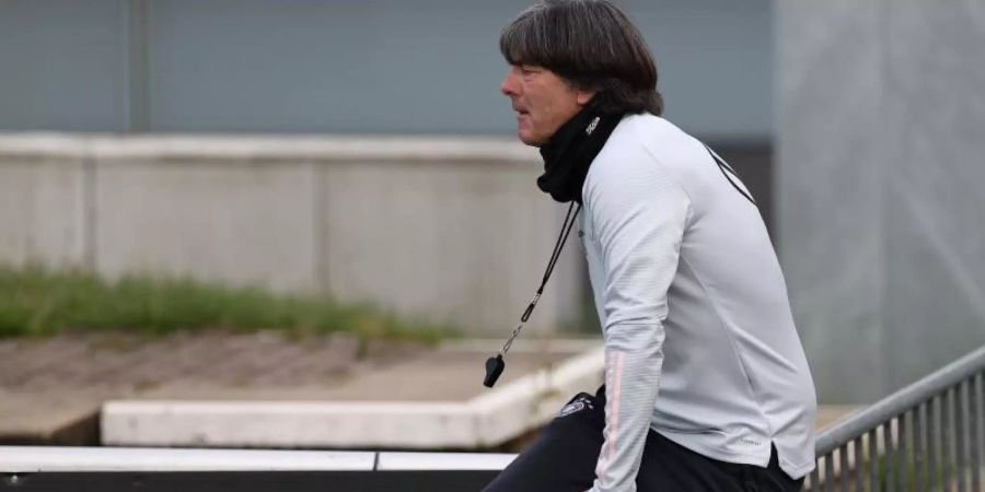 Joachim Löw klettert beim DFB-Training über eine Absperrung. Foto: Christian Charisius/dpa