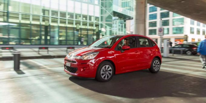 Ein Auto der Mobility, in ikonisch roter Farbe. Mobility e ladestationen