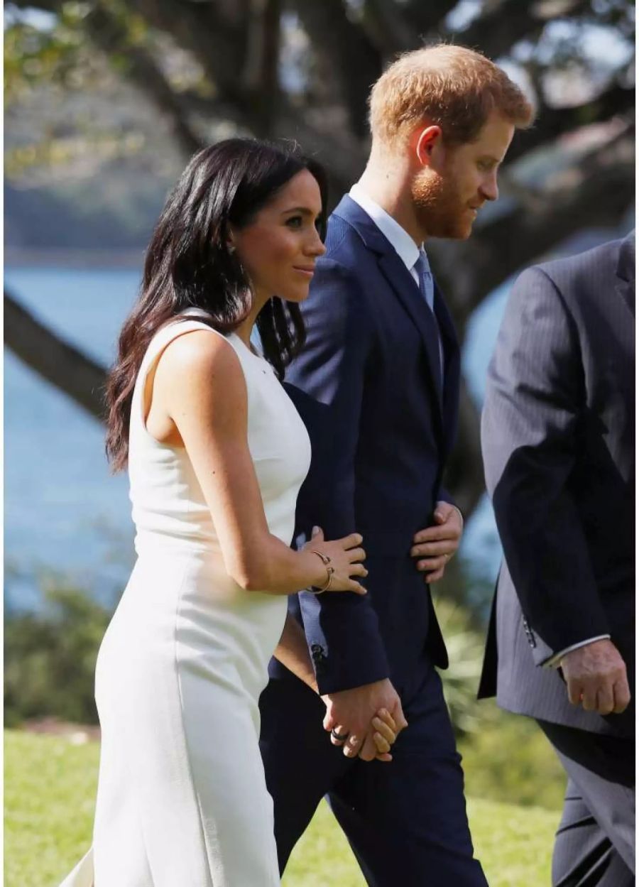 Der kleine Babybauch lässt sich nicht mehr verstecken. Meghan Markle und Prinz Harry bei einem Spaziergang vor dem Admiralty House in Sydney.