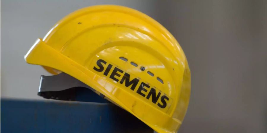 Ein gelber Schutzhelm mit dem Aufdruck «Siemens» liegt in einer Montagehalle.