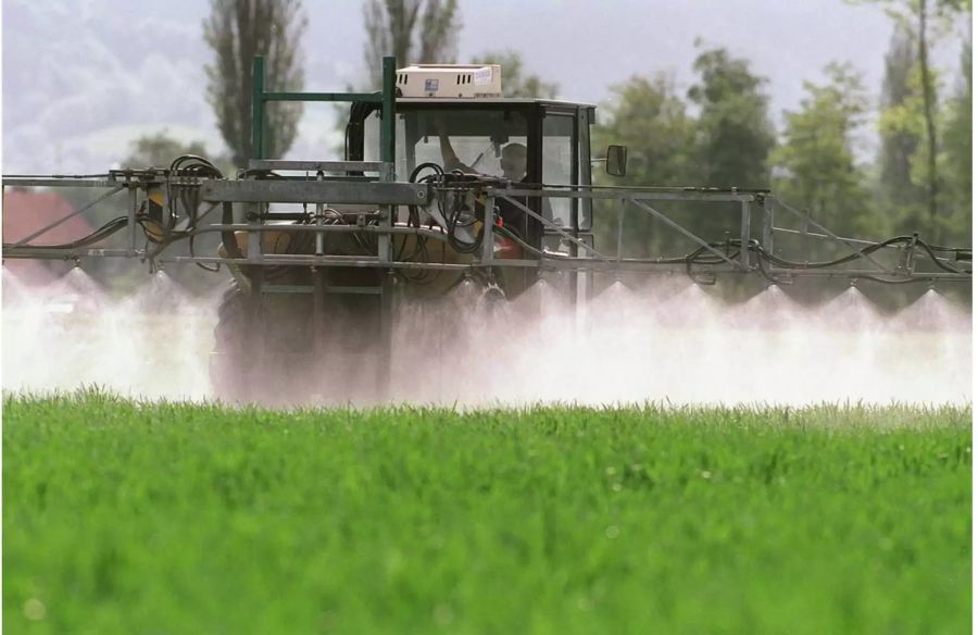 Ein Landwirt versprüht mithilfe seines Traktors Pflanzenschutzmittel in Sargans - Keystone