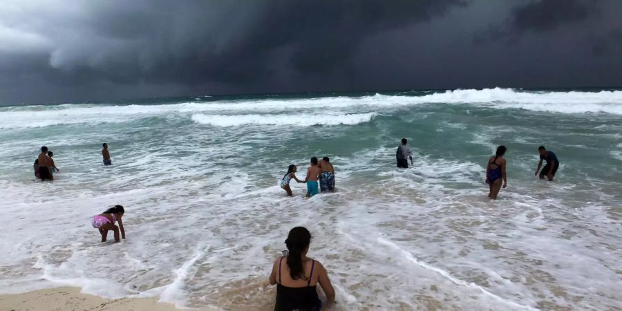 Personen schwimmen am Strand von Cancun in Mexiko.