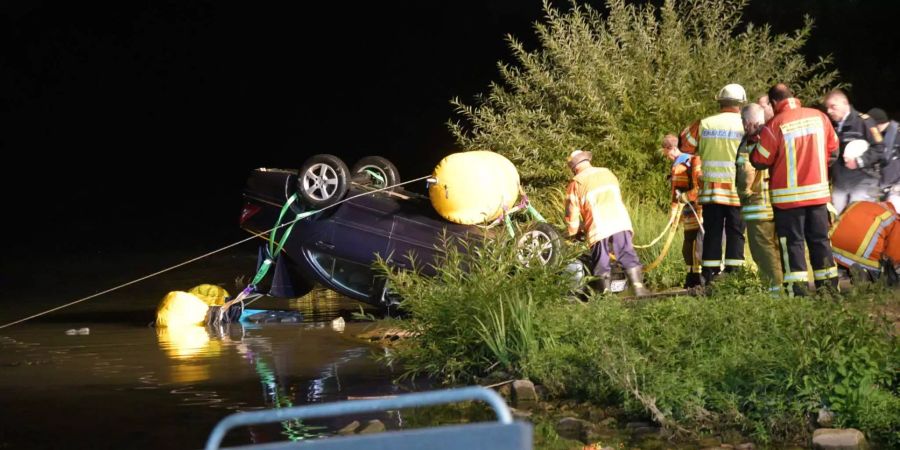 Einsatzkräfte bergen das Auto bei Neckarhausen (D) aus dem Neckar.