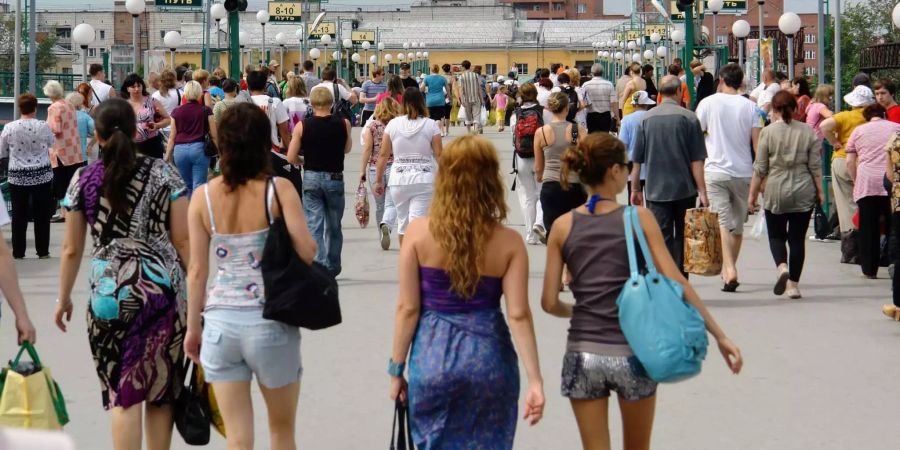 Mehrere Menschen auf einem Bahnhof.