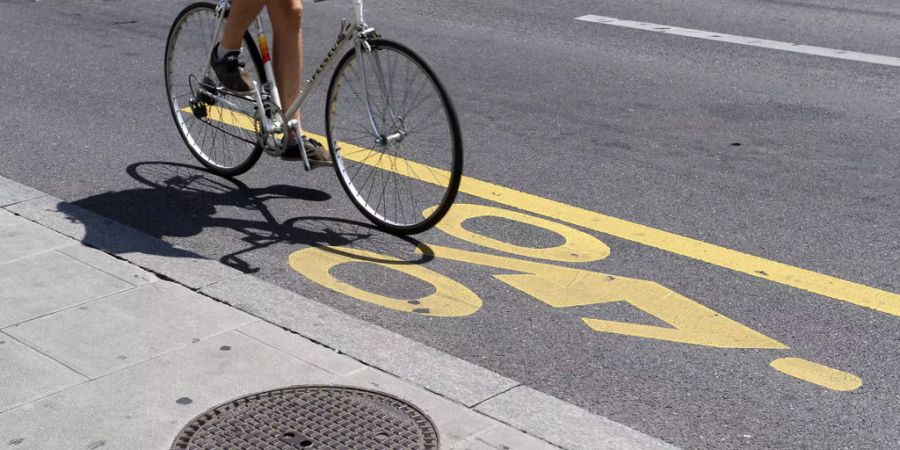 Fahrrad auf einem Fahrradstreifen auf der Strasse - Keystone