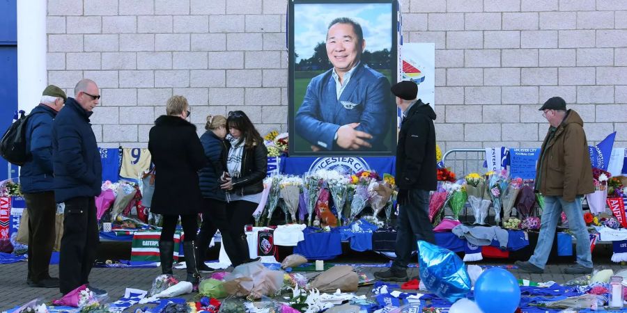 Menschen legen vor dem Stadion von Leicester City Blumen hin.