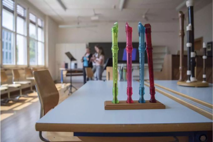 Blockflöten einer Schule und im Hintergrund sind Schüler am Üben - Keystone Blockflöten einer Schule und im Hintergrund sind Schüler am Üben - Keystone