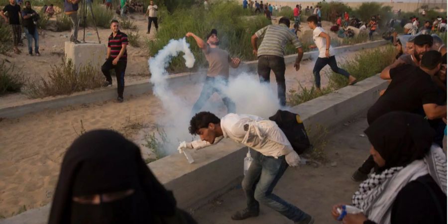 Ein Demonstrant wirft bei einer Demonstration am Eingang des Erez-Grenzübergangs zwischen Gaza und Israel im nördlichen Gazastreifen einen Tränengasbehälter weg, der von israelischen Truppen abgefeuert wurde.