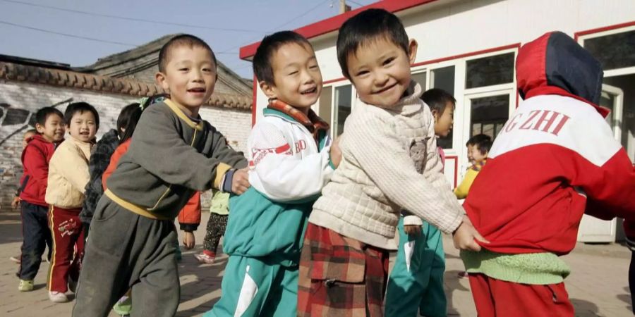 Benachteiligte Schüler aus China spielen während der Pause im Hof.