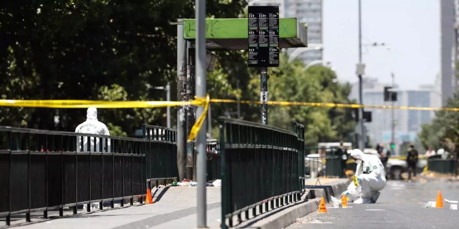 Polizeibeamte untersuchen eine Bushaltestelle in Santiago de Chile.