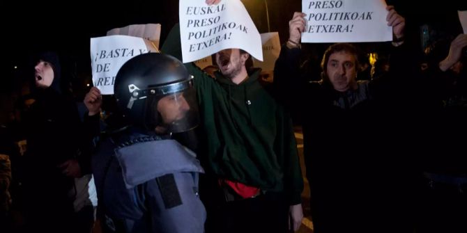 Mehrere Demonstranten und ein Polizist.