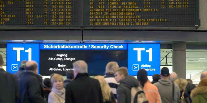 Reisende warten auf dem Flughafen Stuttgart (D) in einer Schlange.