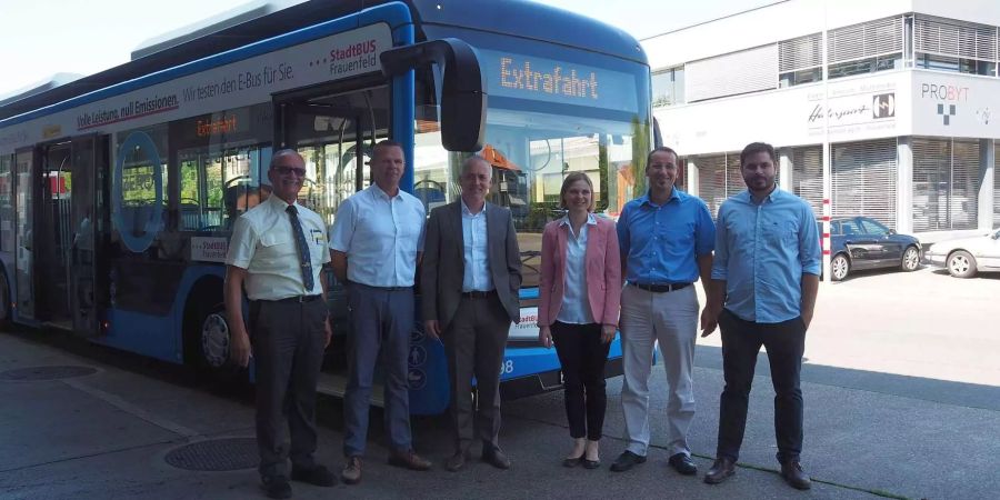 Enzo Gaito, Buschauffeur PostAuto, Roland Fässler, Leiter PostAuto Betriebsstelle Frauenfeld, Markus Winiger, Leiter Betrieb PostAuto Region Ostschweiz, Marianne Kunz-Tobler, Key Account Managerin PostAuto Region Ostschweiz, Stadtrat Urs Müller, Vorsteher Departe-ment Bau und Verkehr der Stadt Frauenfeld und Urs Ambühl, Leiter Stadtbus Frauenfeld, vor dem blau lackierten Testbus - zvg Stadt Frauenfeld