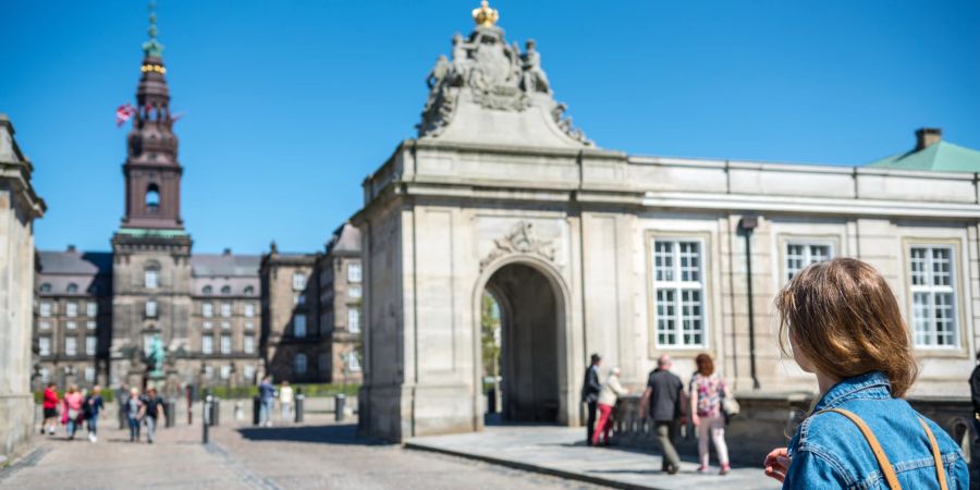 Frau vor alten Gebäude in Kopenhagen.