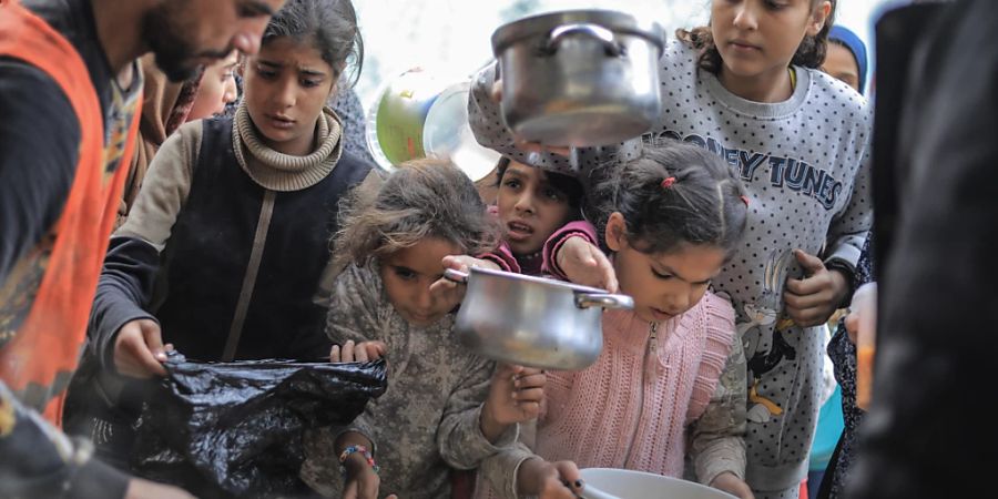 dpatopbilder - Die Not im Gazastreifen wird immer schlimmer. Menschen stehen in Rafah im Süden des abgeriegelten Küstengebiets mit Töpfen, Schalen und Tüten bei einer Essensausgabe an. Foto: Mohammed Talatene/dpa