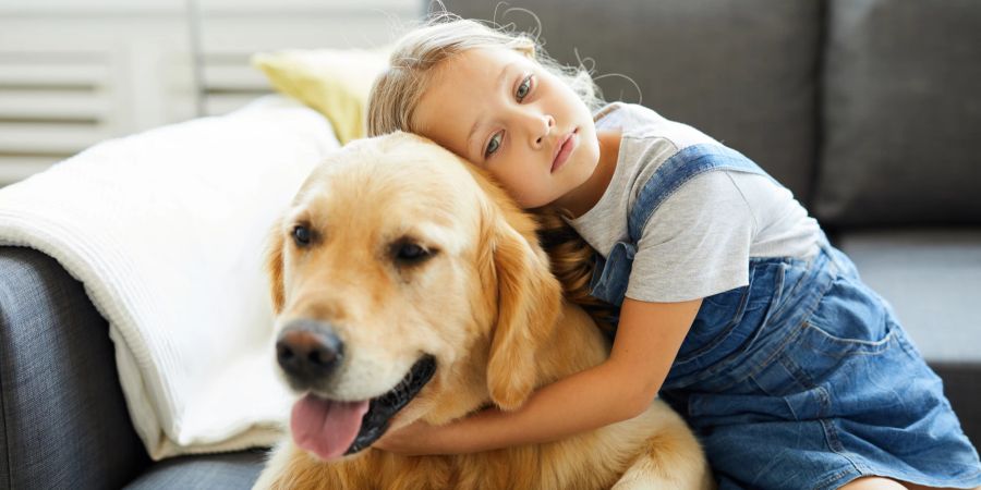 Mädchen kuschelt mit Hund