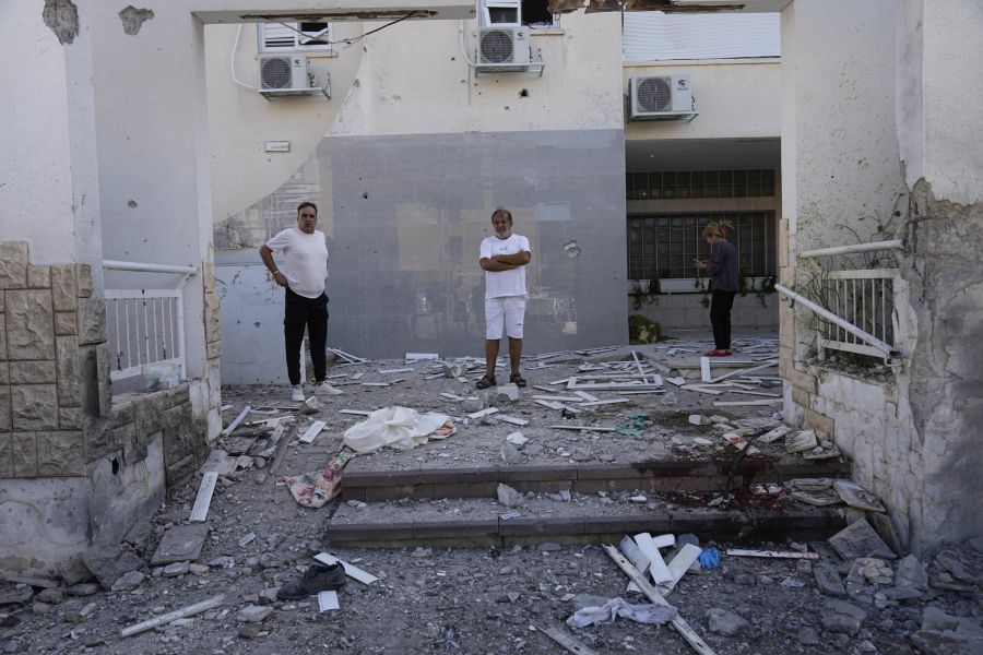 Anwohner betrachten die Schäden nach einem Raketenangriff aus dem Gazastreifen in Ashkelon, Israel, am Samstag, 7. Oktober 2023.