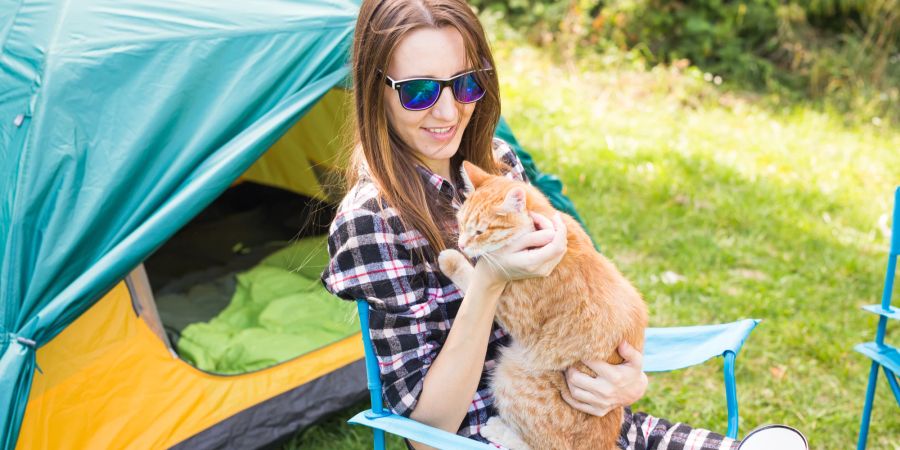 Frau mit Katze am Zelt