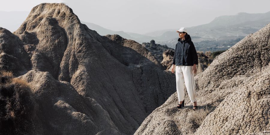 Frau, Model in der Landschaft mit funktionaler Kleidung