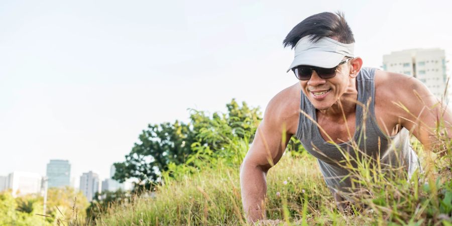 Mann, Training, Liegestütze, Grass, Stadt im Hintergrund