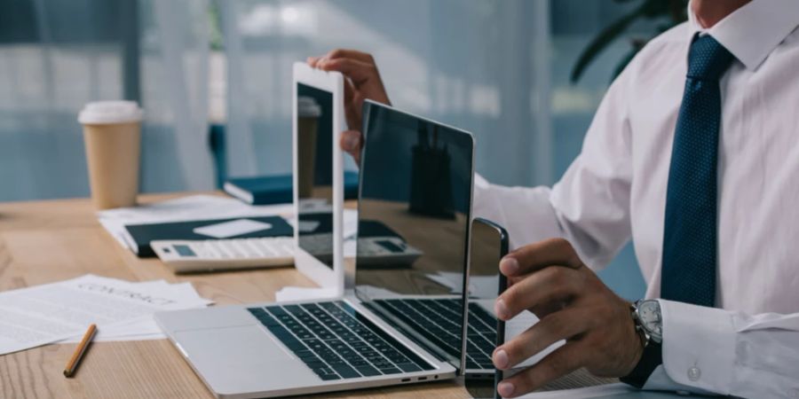 Mann Hemd und Krawatte Schreibtisch Laptops Hand Smartphone