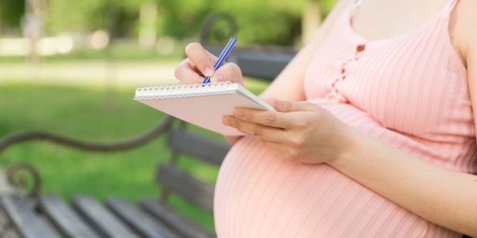 Schwangere macht sich Notizen