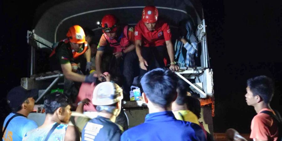Rettungskräfte helfen Bewohnern des Dorfes Maco, sich nach dem Erdrutsch in Sicherheit zu bringen.