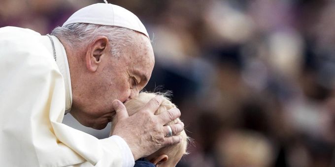Papst Franziskus küsst den Kopf eines Kindes in der Vatikanstadt. vatikanstadt