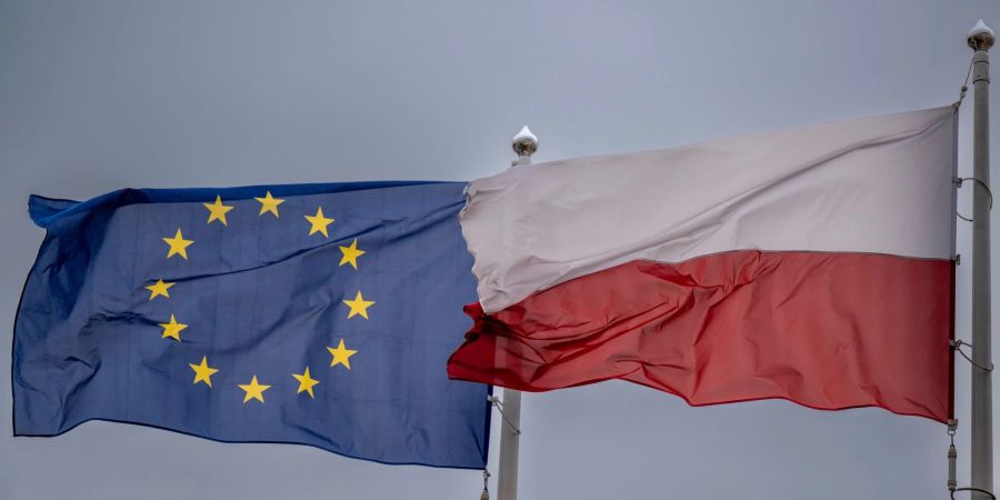 Die Fahnen von Polen und der Europäischen Union wehen im Wind.