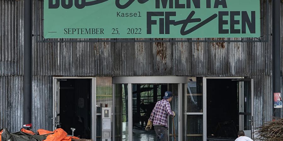 PRODUKTION - Äste liegen unter einer Plane vor der documenta-Halle in Kassel. Die Kunstausstellung geht vom 18.06. bis 25.09.2022. Foto: Swen Pförtner/dpa - ACHTUNG: Nur zur redaktionellen Verwendung im Zusammenhang mit der aktuellen Berichterstattung und nur mit vollständiger Nennung des vorstehenden Credits