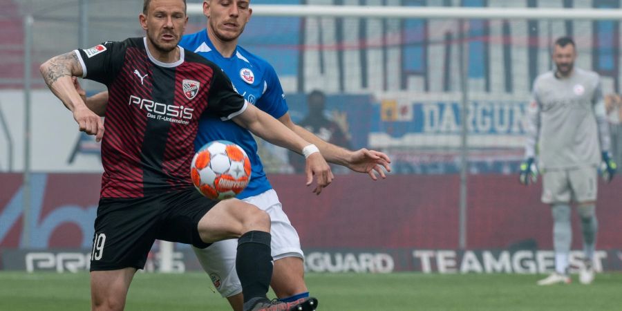 Ingolstadts Marcel Gaus (l) kommt Bentley Baxter Bahn von Hansa Rostock an den Ball.