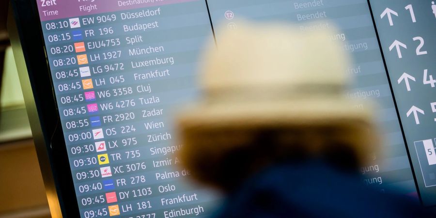 Eine Frau steht am Berliner Flughafen.