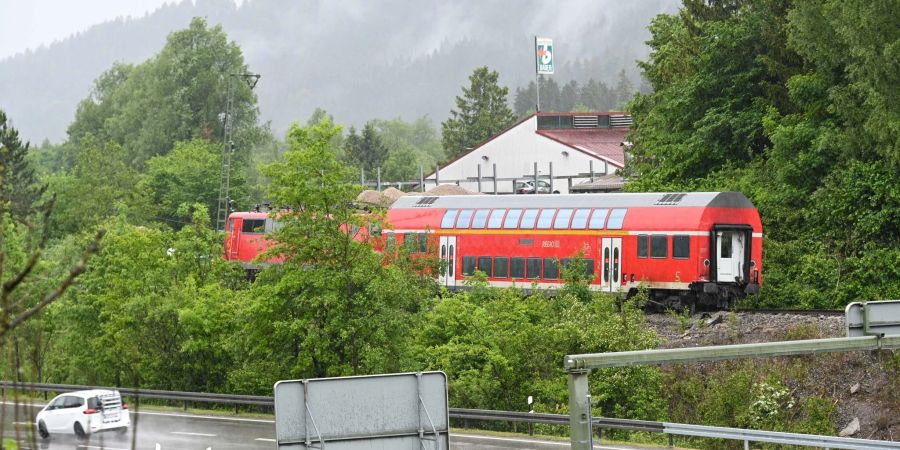 Die Lok und ein Wagon des verunglückten Zugs stehen an der Unglücksstelle auf dem Gleis.