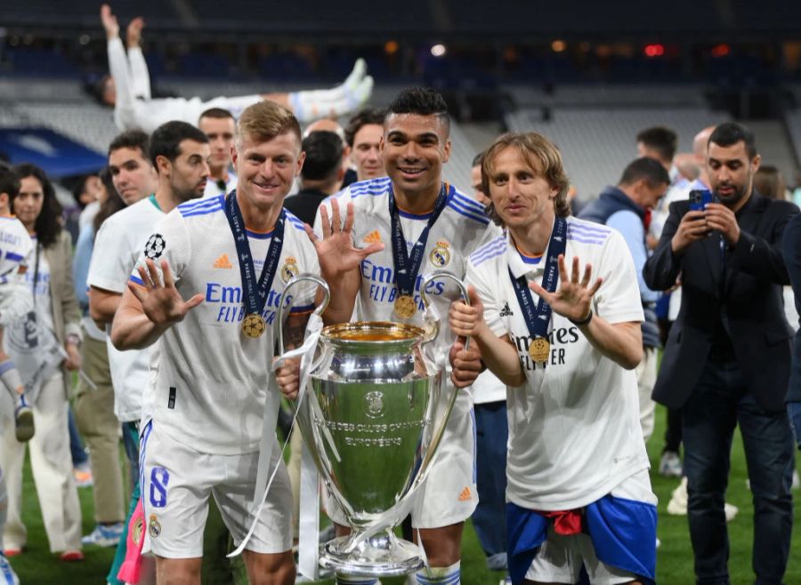 Toni Kroos (links) freut sich mit Casemiro (Mitte) und Luka Modric über den Gewinn der Champions League.