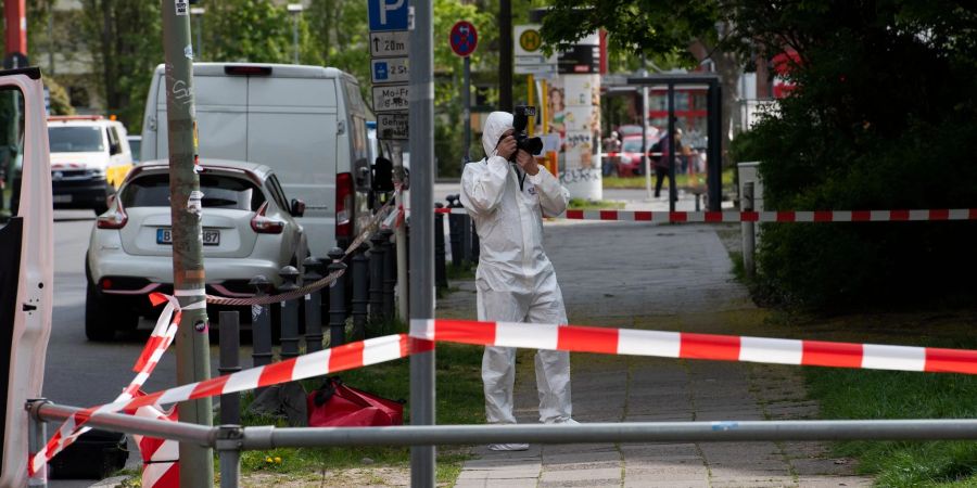 Ein Mitarbeiter der Spurensicherung dokumentiert die Lage am Tatort in der Berliner Maximilianstrasse, wo eine Frau auf offener Strasse getötet worden ist.