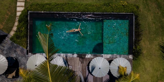 Eine Frau badet im Swimmingpool (Symbolbild) Swimmingpool
