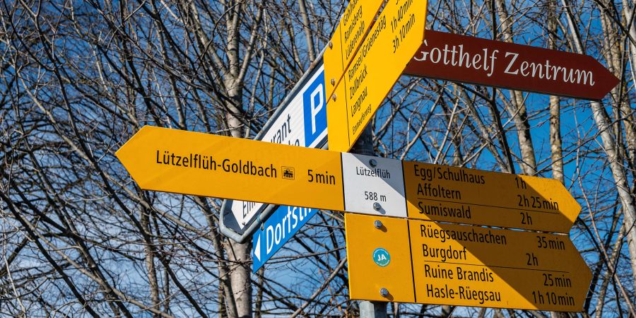 Ein Wanderwegweiser und das Gotthelf Zentrum Wegweiser in Lützelflüh.