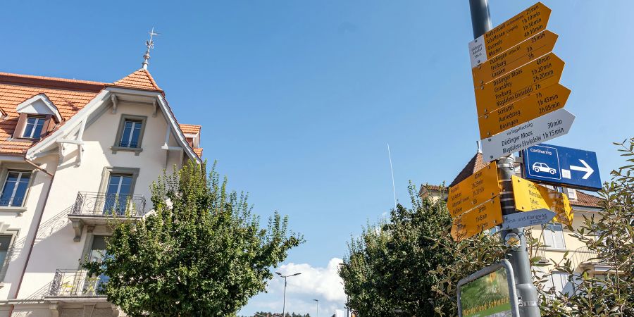 Ein Wanderwegweiser beim Bahnhof Düdingen.