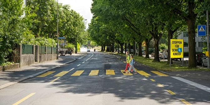 Kinder überqueren die Strasse