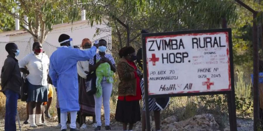 Bewohnern wird in Zvimba, Simbabwe, die Temperatur gemessen, bevor sie sich im örtlichen Krankenhaus behandeln lassen können. Foto: Tsvangirayi Mukwazhi/AP/dpa