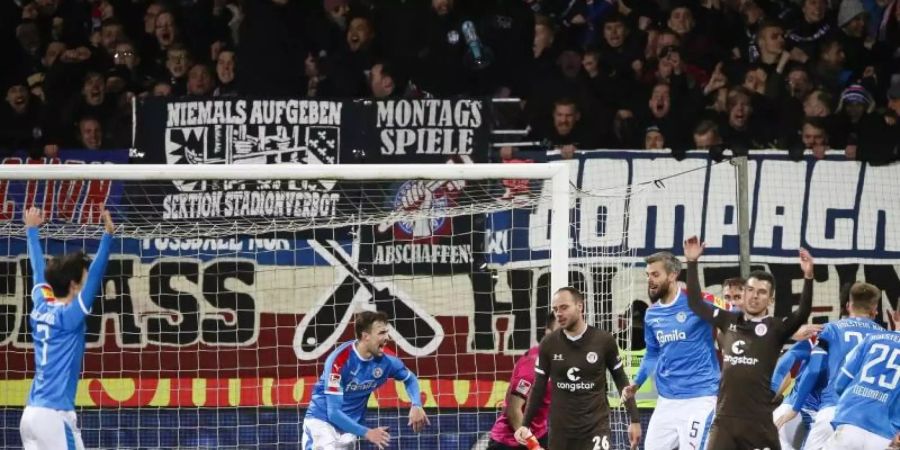 Die Spieler von Holstein Kiel feiern das Tor zum 2:1 durch Janni Serra (2.v.l.) gegen den FC St. Pauli. Foto: Christian Charisius/dpa