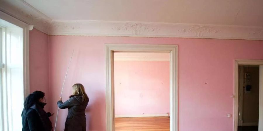 Besser vorher prüfen: Interessenten messen bei einer Wohnungsbesichtigung eine Mietwohnung aus. Foto: Axel Heimken/dpa
