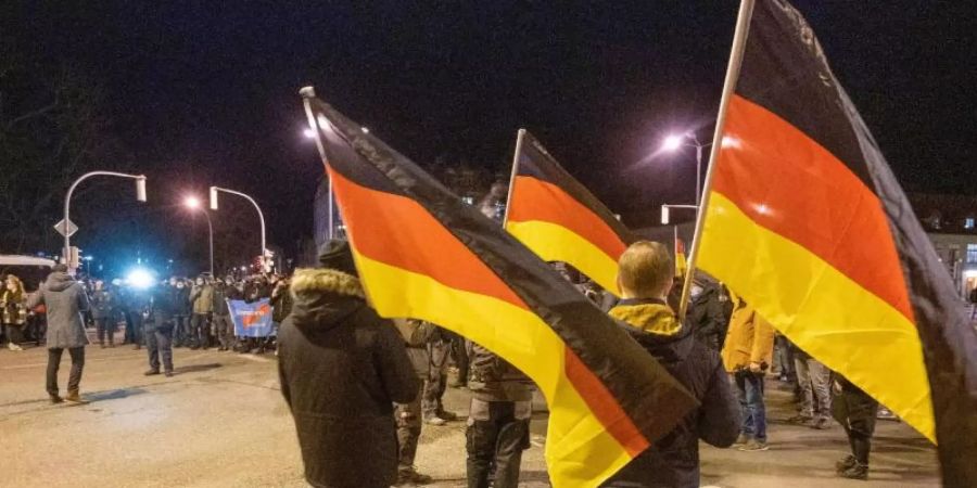 Teilnehmer einer Demonstration gegen die Corona-Massnahmen tragen Deutschland-Fahnen. Foto: Stefan Sauer/dpa