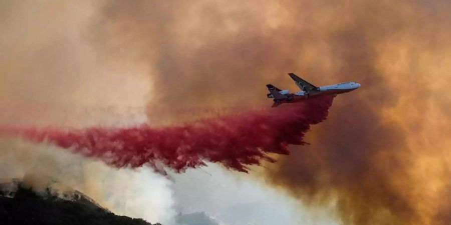 Ein Tankflugzeug wirft in Goleta, Kalifornien, Löschmittel auf einen Waldbrand ab. Das Alisal-Feuer erstreckte sich über mehr als 22 Quadratmeilen (57 Quadratkilometer) in den Santa Ynez Mountains westlich von Santa Barbara. Foto: Ringo H.W. Chiu/AP/dpa