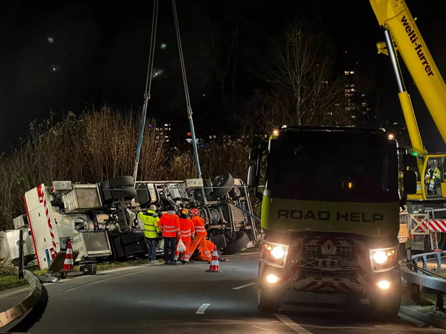 Einsatzkräfte machen Seile für die Bergung am Lkw fest.