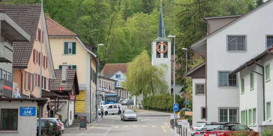 Ortsstrasse in Fällanden im Bezirk Uster mit Kreisel und Blick auf die Kirche.