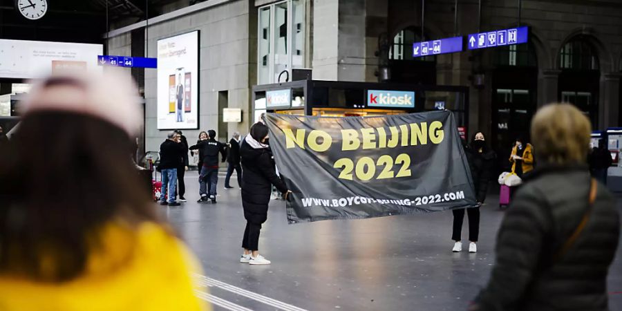 Im Zürcher Hauptbahnhof entrollen tibetische Aktivisten am Dienstag ein schwarzes Banner mit der Botschaft «No Beijing 2022».