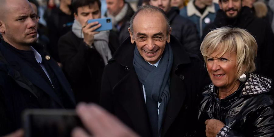 Eric Zemmour (M), rechtsextremer Journalist aus Frankreich, macht ein Foto mit einem Fan bei einem Besuch der Kathedrale von Marseille. Foto: Daniel Cole/AP/dpa