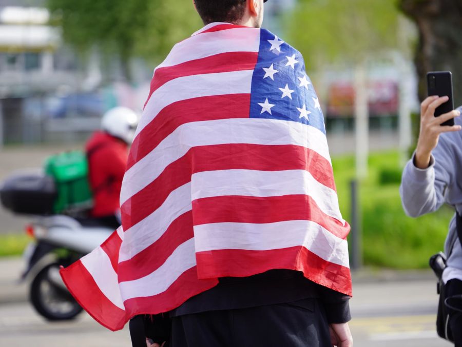 Ein Mann mit US-Flagge vor dem Auftritt Obamas im Hallenstadion.