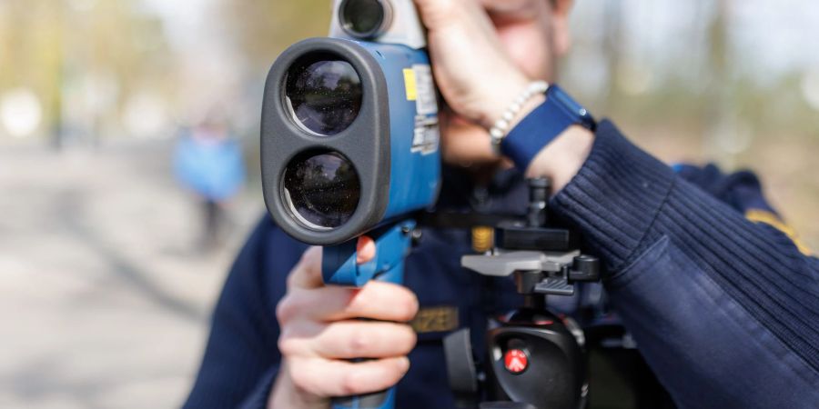 Ein Polizist schaut während des sogenannten Blitzmarathons durch ein Laserhandmessgerät.